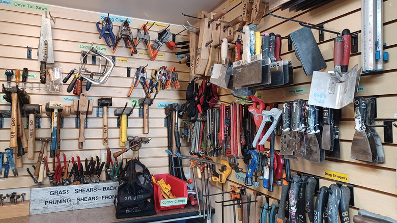 A wide variety of hand and power tools organized on shelving and pegboards in the Oakland Tool Lending Library.