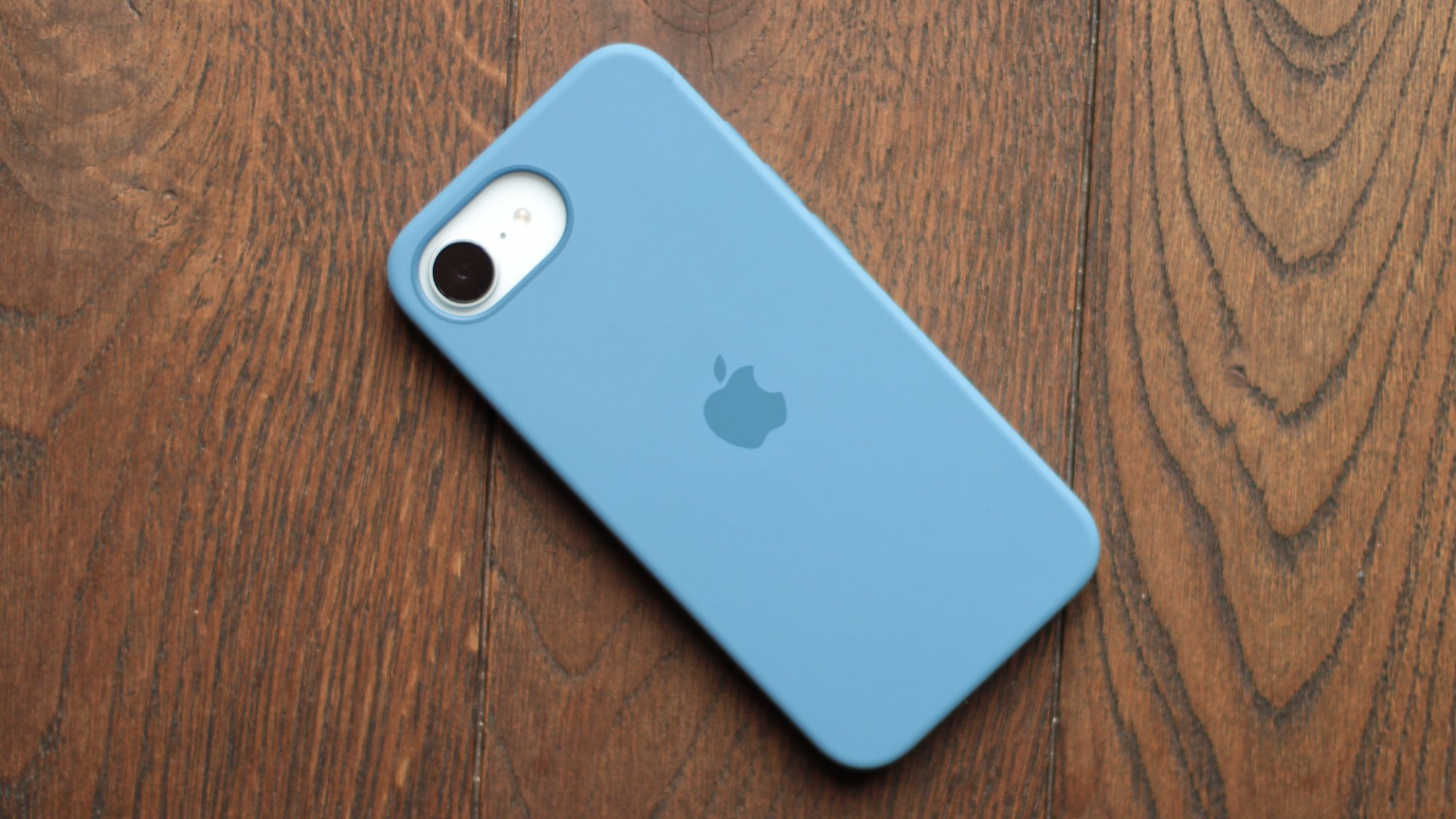 Macro shot of the single 48MP camera lens on the back of the white iPhone 16e.