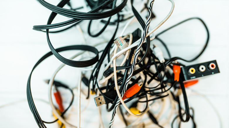 A messy pile of tangled black and white electronic connector cables.