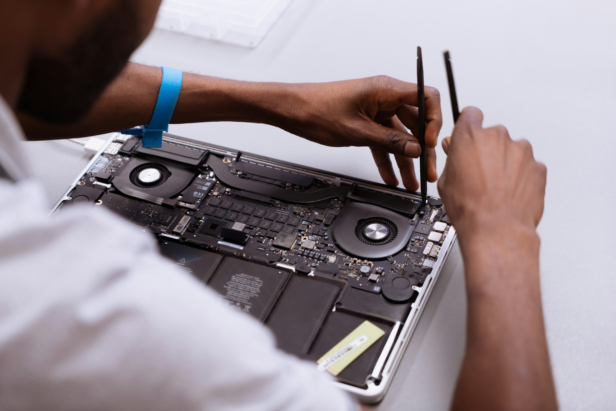 Technician's view of a MacBook's internal motherboard and battery during a service.