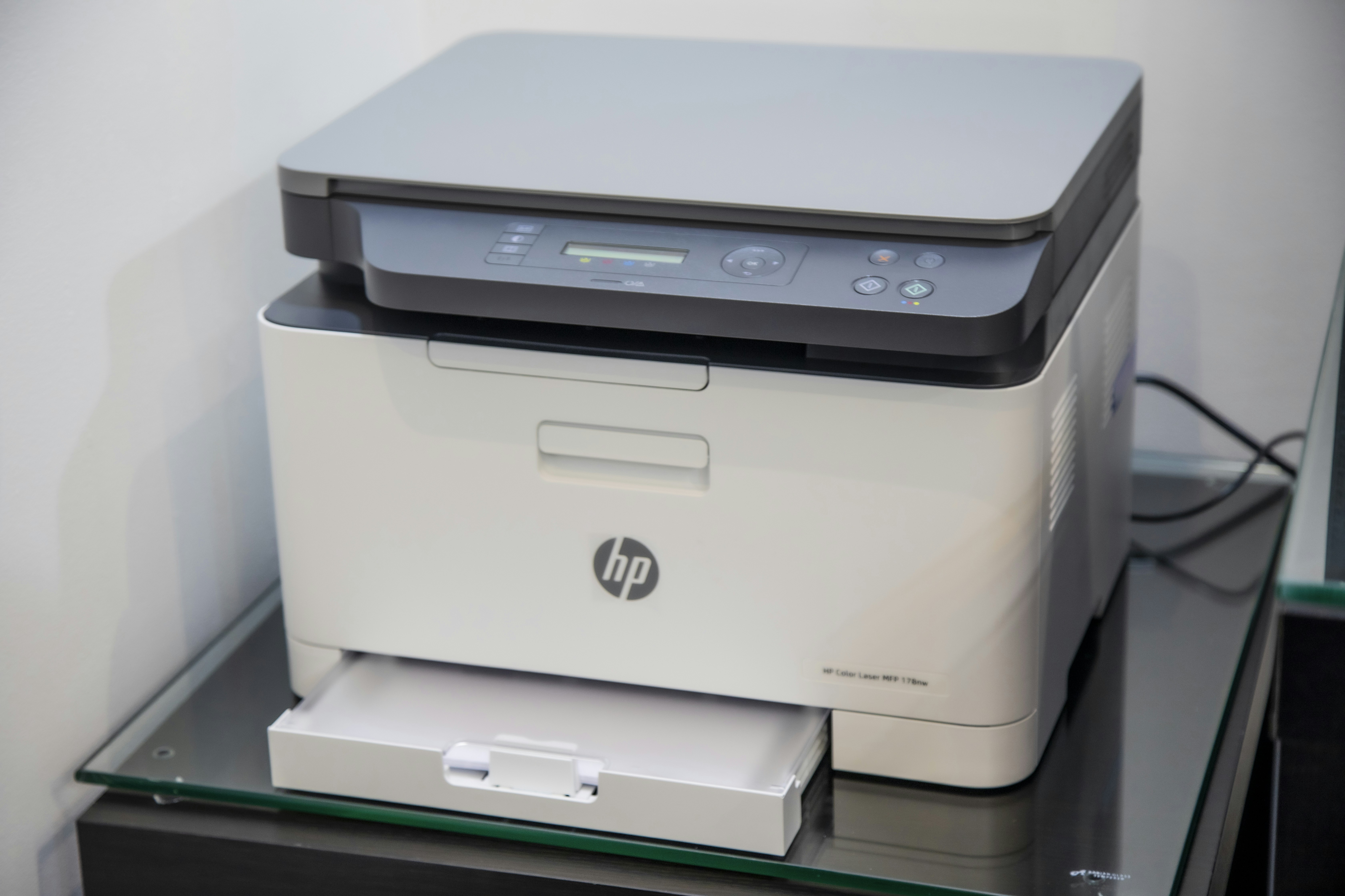 Close-up of a high-quality color laser office printer producing a document.