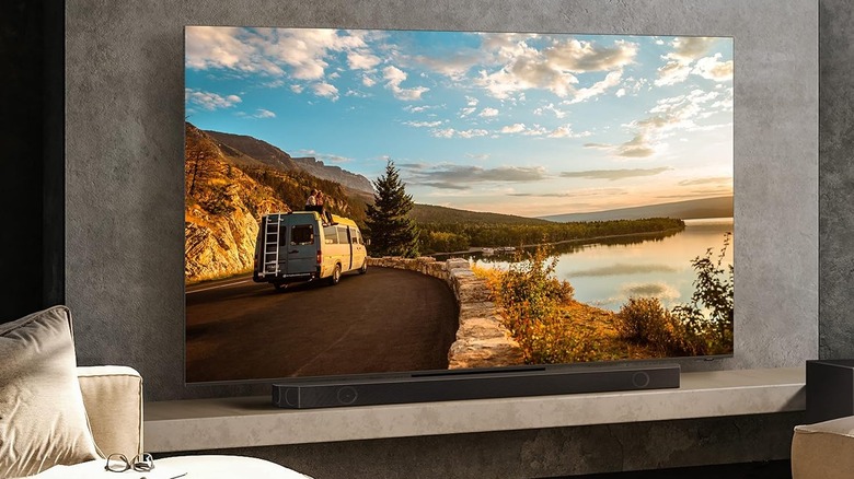 A Samsung HW-Q990C soundbar mounted on a wall below a high-definition television.