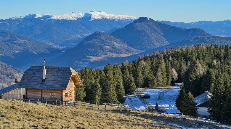 A scenic wooden cabin on a snowy mountain slope.